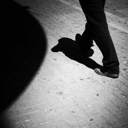 Low section of man standing on tiled floor