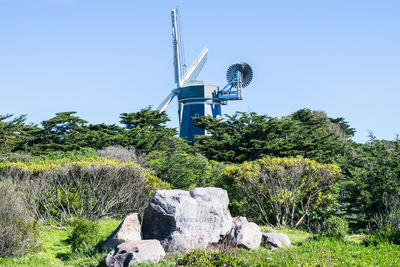 Traditional windmill on field against clear sky