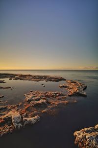 Scenic view of sea against clear sky at sunset