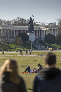 Rear view of people at park against sky