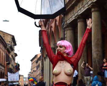 Portrait of woman standing against pink city