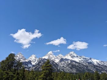 Scenic view of snowcapped mountains against blue sky