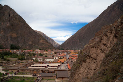 Panoramic view of townscape by mountains against sky
