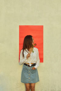 Full length of woman standing against wall