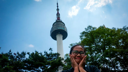 Portrait of woman against tower in city