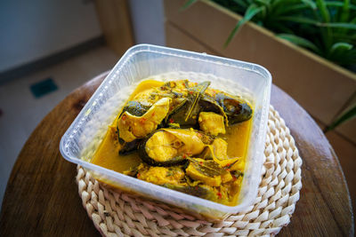 River fish pangasius sutchi, malaysia tradisional food ikan patin tempoyak in a takeaway container.