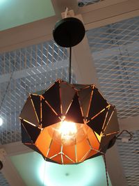 Low angle view of illuminated pendant light hanging on ceiling