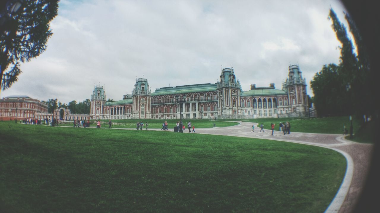 architecture, built structure, building exterior, grass, sky, cloud - sky, lawn, tree, cloud, cloudy, city, incidental people, travel destinations, green color, park - man made space, famous place, tourism, day, outdoors