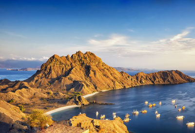 Scenic view of mountain by sea against sky