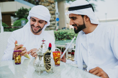 Smiling business people having discussion while sitting at cafe