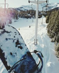 Overhead cable car over snow covered field against mountain