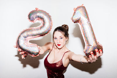 Young woman celebrating her 21st birthday illuminated with hard flash light.