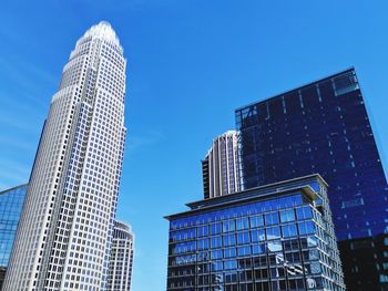 Low angle view of modern buildings against blue sky