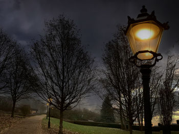 Low angle view of illuminated street light against sky