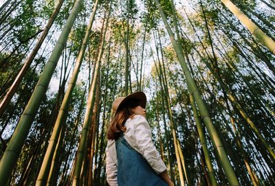 Low angle view of woman looking at forest