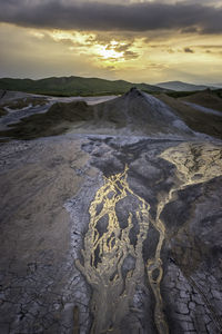 Scenic view of volcanic landscape against sky during sunset