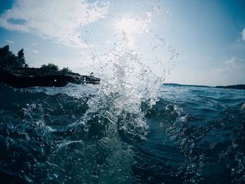 Close-up of sea splashing against sky
