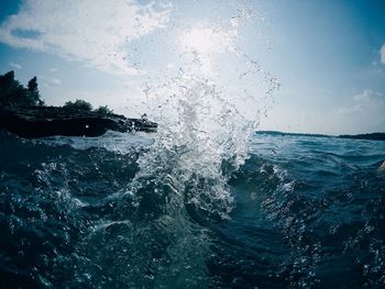 Close-up of sea splashing against sky