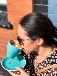 Young woman in silk dress is drinking latte art coffee. young candid woman drinking morning coffee