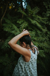 Midsection of woman standing by tree against plants