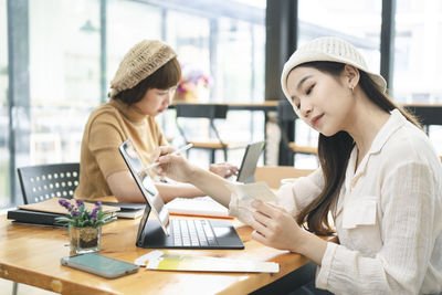 Young woman using smart phone on table