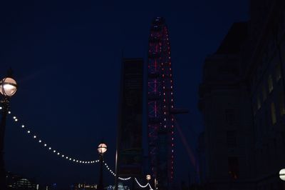 Low angle view of illuminated christmas lights against sky at night