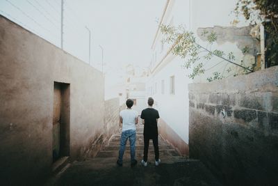 Rear view of men walking on road