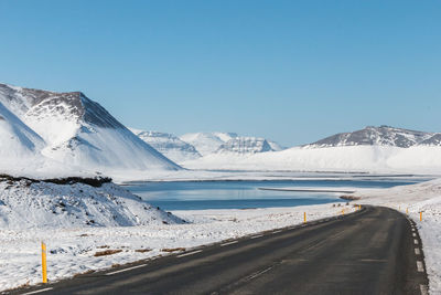 Scenic view of snowcapped mountains against clear blue sky