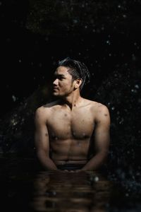 Young man swimming in water at night