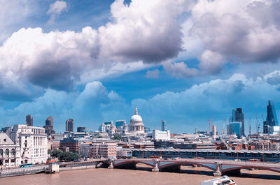 Buildings in city against cloudy sky