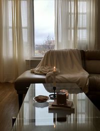 Coffee cup on table against window at home