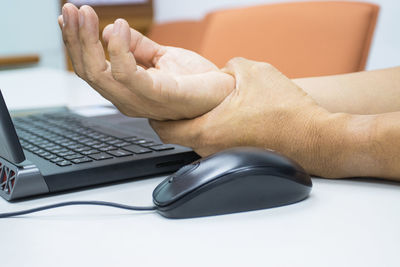 Midsection of man using mobile phone on table