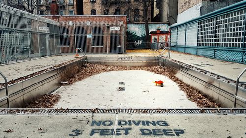 No diving sign at edge of empty swimming pool