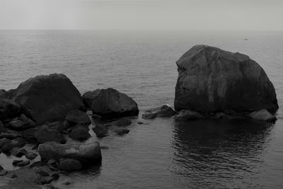 Rock formation in sea against sky