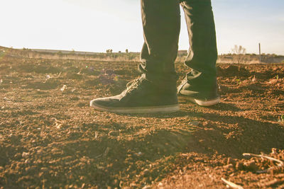 Low section of person standing on field