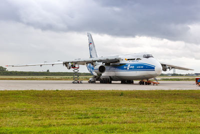 Airplane on airport runway against sky