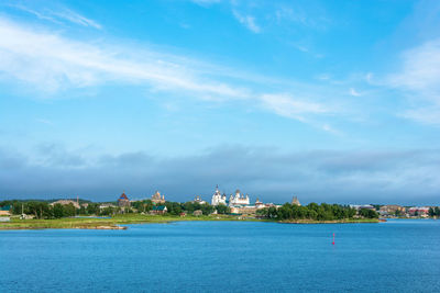 View of buildings at waterfront against cloudy sky