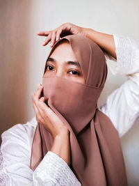 Portrait of a young woman covering face