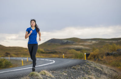 Beautiful woman jogging in rural area in iceland