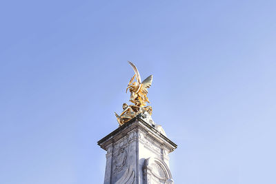 Low angle view of statue against blue sky