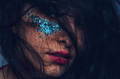 Close-up of woman with glitter on her face