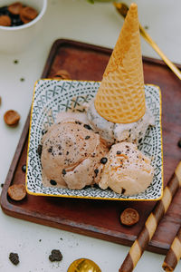 Chocolate flavored gelato and some toppings in a wooden bowl