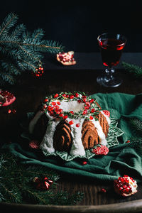 Gingerbread bundt cake for christmas with pomegranate and christmas decorations over dark background