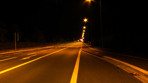 Illuminated empty road at night