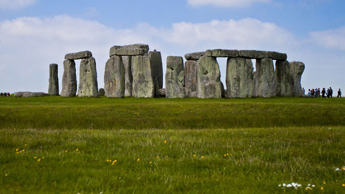 Stonehenge on grassy field against sky