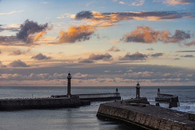 Pier over sea against sky during sunset