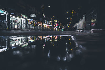 Illuminated road in city against sky at night