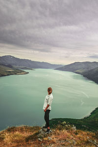 Full length of man standing on shore against sky