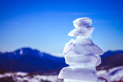 Close-up of snow on mountain against blue sky