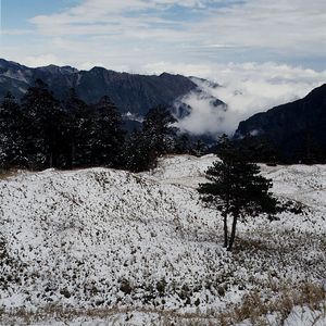 Scenic view of mountains against cloudy sky